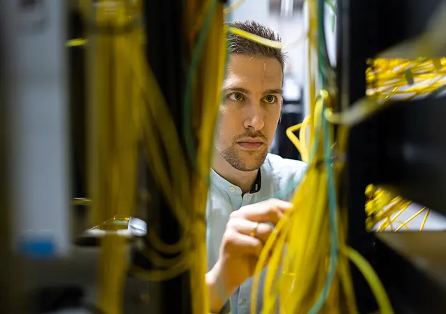 IT Technician working with wires in server room